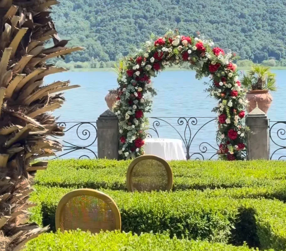 Arco floreale bianco e rosso per matrimonio con vista sul Lago d'Iseo